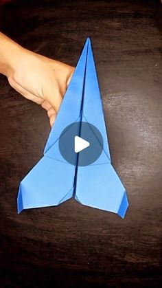 someone is holding an origami bird on a table with the video below it