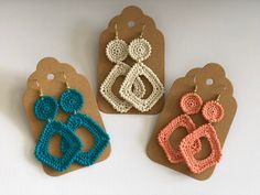 three crocheted earrings are displayed on brown tags