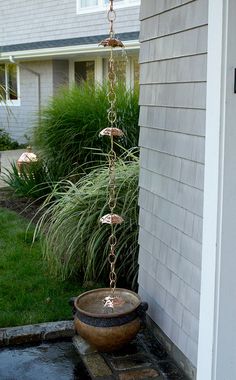 a potted plant hanging from a chain in front of a house