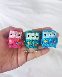 three small crocheted toys are in the palm of someone's hand