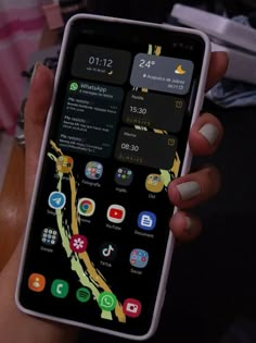 a person holding an iphone in their hand with icons on the screen and other app icons