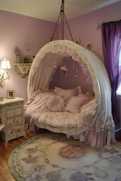 a canopy bed in a girls bedroom with pink walls and purple curtains on the windowsill