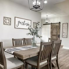 a dining room table with chairs and a vase filled with flowers on top of it