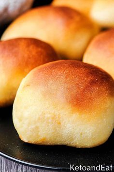 bread rolls sitting on top of a black plate