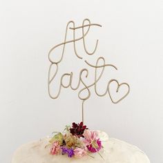 a cake with the word love spelled in cursive writing on top and flowers