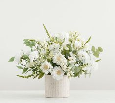 a vase filled with white flowers on top of a table