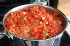 a pot filled with tomatoes and onions on top of a stove