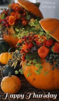 an arrangement of pumpkins and gourds on a table