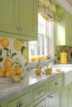 a kitchen with green cabinets and yellow fruit painted on the wall next to the sink