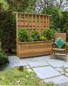 a wooden bench sitting in the middle of a garden next to a planter filled with flowers