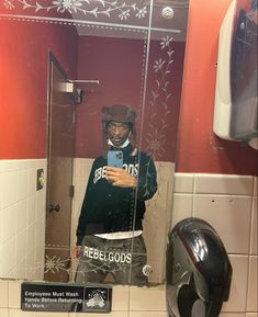 a man taking a selfie in the bathroom mirror with his helmet and goggles on