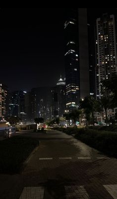 the city skyline is lit up at night with skyscrapers in the backround