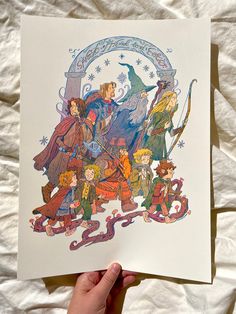 a hand holding up a paper with an image of wizard's family on it