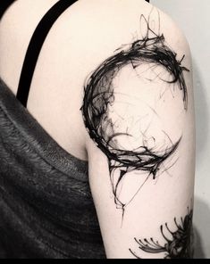 a black and white photo of a woman's arm with an abstract tattoo design on it