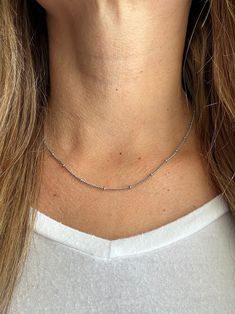 Our favorite layering chain necklace is the Delilah Beaded Satellite chain.    This delicate Stainless Steel or 14K Gold Plated Stainless Steel chain necklace sits close to the neck and features tiny 2mm beads every 2cm.    Wear it on its own for a simple and chic look or pair it with your other favorite necklaces for the ultimate layered look.   Bring instant dimension and flair to your stack with the Delilah Beaded Satellite chain.  Safe for sensitive skin & shower safe. ITEM DESCRIPTION ❤ Choker Necklace ❤ Color:  available in Silver or 14K Yellow Gold ❤ Length: 15 in + 2 in extender ❤ Material: Stainless Steel or 14K Gold Plated Stainless Steel ❤ Sold Individually  ❤ Free Shipping  P R O M O T I O N ✦ 20% Discount is applied for purchases of 2 or more products. Coupon Code: 20FORYOU ✦ Everyday Station Necklace With Satellite Chain, Dainty Beaded Chain Charm Necklace For Everyday, Minimalist Beaded Necklace With Adjustable Chain, Everyday Round Beads Charm Necklace, Dainty Choker Necklace With Tiny Beads, Dainty Beaded Choker Chain Necklace, Dainty Tiny Beads Choker Necklace, Silver Necklaces With Beaded Chain For Layering, Silver Double Strand Beaded Necklaces For Layering