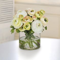 a glass vase filled with white and yellow flowers