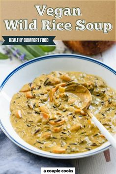 a bowl of vegan wild rice soup with a spoon in it on a table