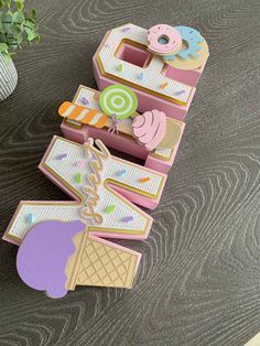 an ice cream box with doughnuts and candy on it sitting next to a potted plant