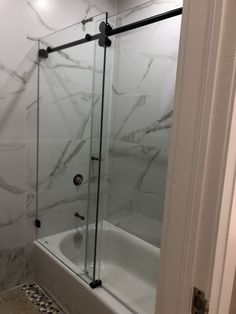 a bath tub sitting next to a walk in shower