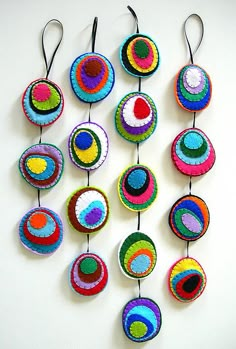 a group of crocheted circles hanging from hooks on a wall next to each other