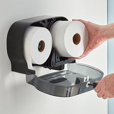 a person holding two rolls of toilet paper