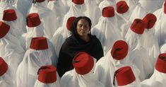 a woman surrounded by white and red hats