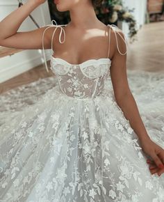 a woman in a white wedding dress sitting on the floor with her hands behind her head