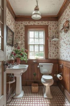 a bathroom with a toilet, sink and window in the wall next to it's tiled floor