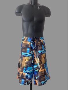 Love the graphic digital print on these vintage board shorts. Made by Maui and Sons, the fit is classic 80s: oversized and long. 2" wide waistband has black woven cord with white Maui and Sons logo printed at ends laced through black metal grommets. Velcro fly front closure. One flap front pocket on side of right leg with solid black flap embroidered with white logo, small rubber logo tab hangs down from tab. Back has round rubber logo at center of waistband. Contrasting black double needle tops Printed Blue Shorts For Beach Season, Blue Printed Shorts For Beach Season, Retro Surfing Bottoms For Summer, Beachwear Swim Trunks With Graphic Print, Retro Swim Trunks With Built-in Shorts For Beach, Blue Graphic Print Beach Bottoms, Blue Graphic Print Bottoms For Summer, Beach Bottoms With Multicolor Graphic Print, Multicolor Graphic Print Beach Bottoms