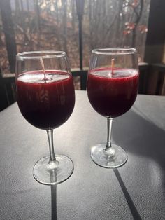 two glasses filled with liquid sitting on top of a table