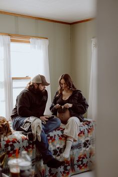 two people sitting on a bed looking at something