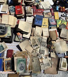 many old books are piled on top of each other