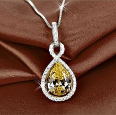 Your very own drop of sunshine to take with you everywhere you go! Adorned with intricately faceted cubic zirconia that capture the light in a cascade of sparkles, the necklace is platinum plated for a bright finish which enhances the intricate detailing and conveys a modern take on old elegance. Hanging from a delicate box chain 18" (approx. 45cm) in length, the pendant measures 1" (approx. 2.5cm) in length including the bail and 0.5" (approx. 1.4cm) wide. Overall weight of the necklace: 5.8g. White Gold Pendant Necklace, Fancy Jewelry Necklace, Cubic Zirconia Necklace, Wedding Gifts For Bridesmaids, Long Beaded Necklace, Halo Pendant, Feather Pendant, Flower Pendant Necklace, Yellow Citrine