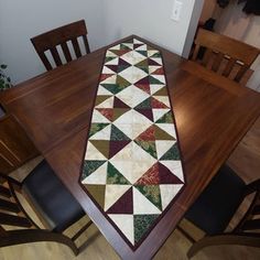 a dining room table with a quilted runner on it