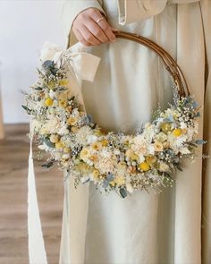 a person holding a wreath with flowers on it