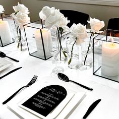 the table is set with white roses and candles