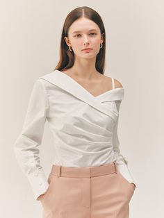 This product is a Miriam one-shoulder shirt blouse that offers a modern twist on classic shirting. The design features an asymmetric neckline that reveals one shoulder, adding an element of allure. The blouse's tailored fit and structured cuffs provide a contrast to the fluidity of the one-shoulder drape, creating a garment that is both unique and sophisticated. - The one-shoulder design presents an elegant take on contemporary shirting.- Tailored to fit, the blouse maintains a professional Elegant Fitted Blouse With Asymmetrical Neckline, Fitted Blouse With Asymmetrical Neckline For Formal Occasions, Modern White Top With Asymmetrical Neckline, Modern Fitted Top With Asymmetrical Neckline, Chic Asymmetrical Neckline Blouse For Formal Occasions, Elegant One-shoulder Blouse For Formal Occasions, Fitted Off-shoulder Blouse For Work, Elegant Asymmetrical Blouse For Office, Elegant Asymmetrical Tops For Office