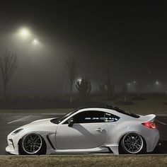 a white sports car parked in the parking lot at night