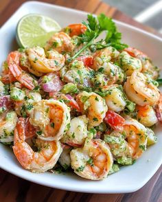 a white bowl filled with shrimp and garnished with cilantro