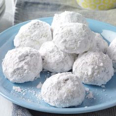 a blue and white plate topped with snowball cookies