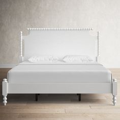 a white bed sitting on top of a hard wood floor