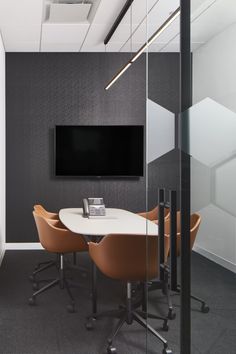 an office meeting room with chairs and a flat screen tv mounted on the wall above it