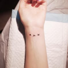 a woman's wrist with three birds on it