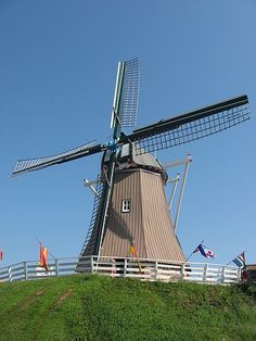 a windmill sitting on top of a green hill