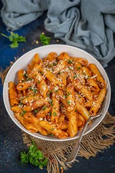 a bowl filled with pasta covered in sauce and parmesan cheese