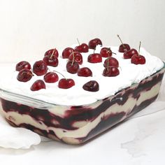 a cake with white frosting and cherries on top