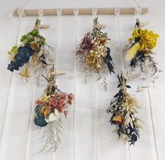 several dried flowers are hanging on a rope