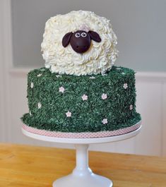 a cake decorated with grass and a sheep on top