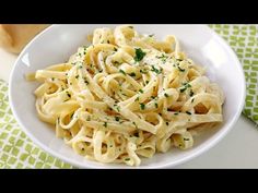 a white bowl filled with pasta on top of a table