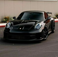 a black sports car parked in front of a building